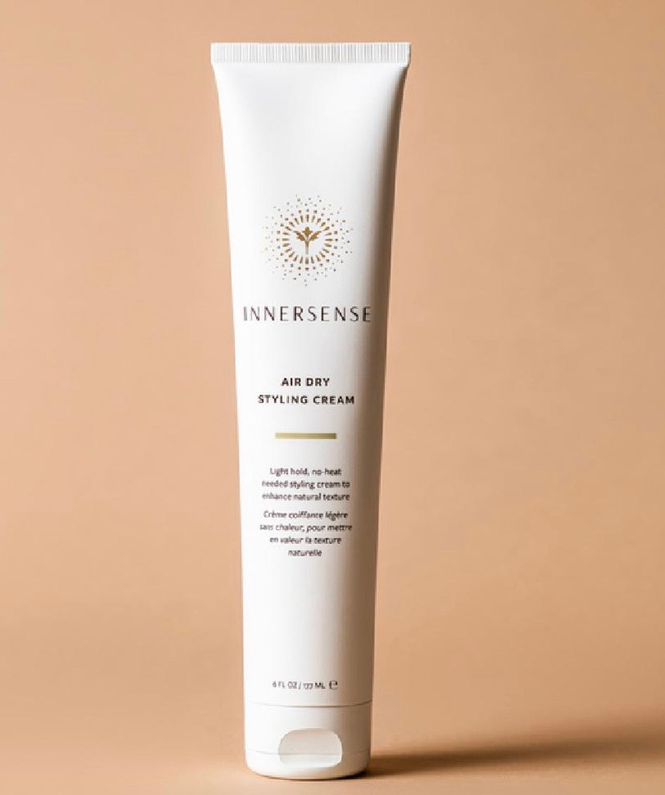 Innersense Air Dry Styling Cream tube on a beige background