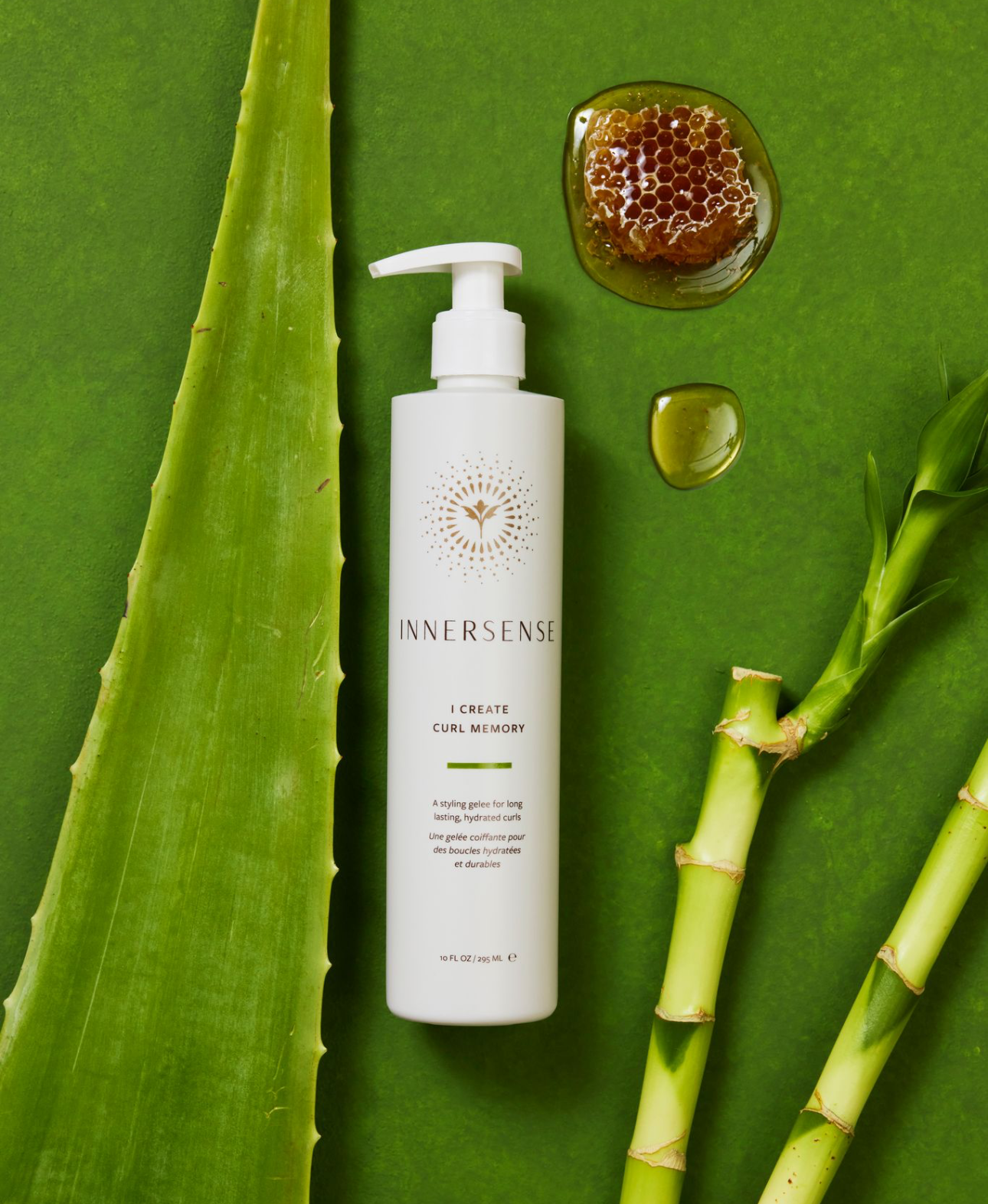 White bottle with pump on a green background with aloe vera leaves and bamboo.
