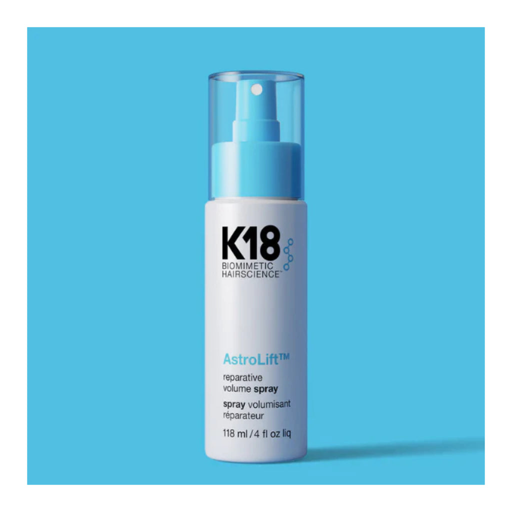 K18 AstroLift hair spray bottle on a blue background
