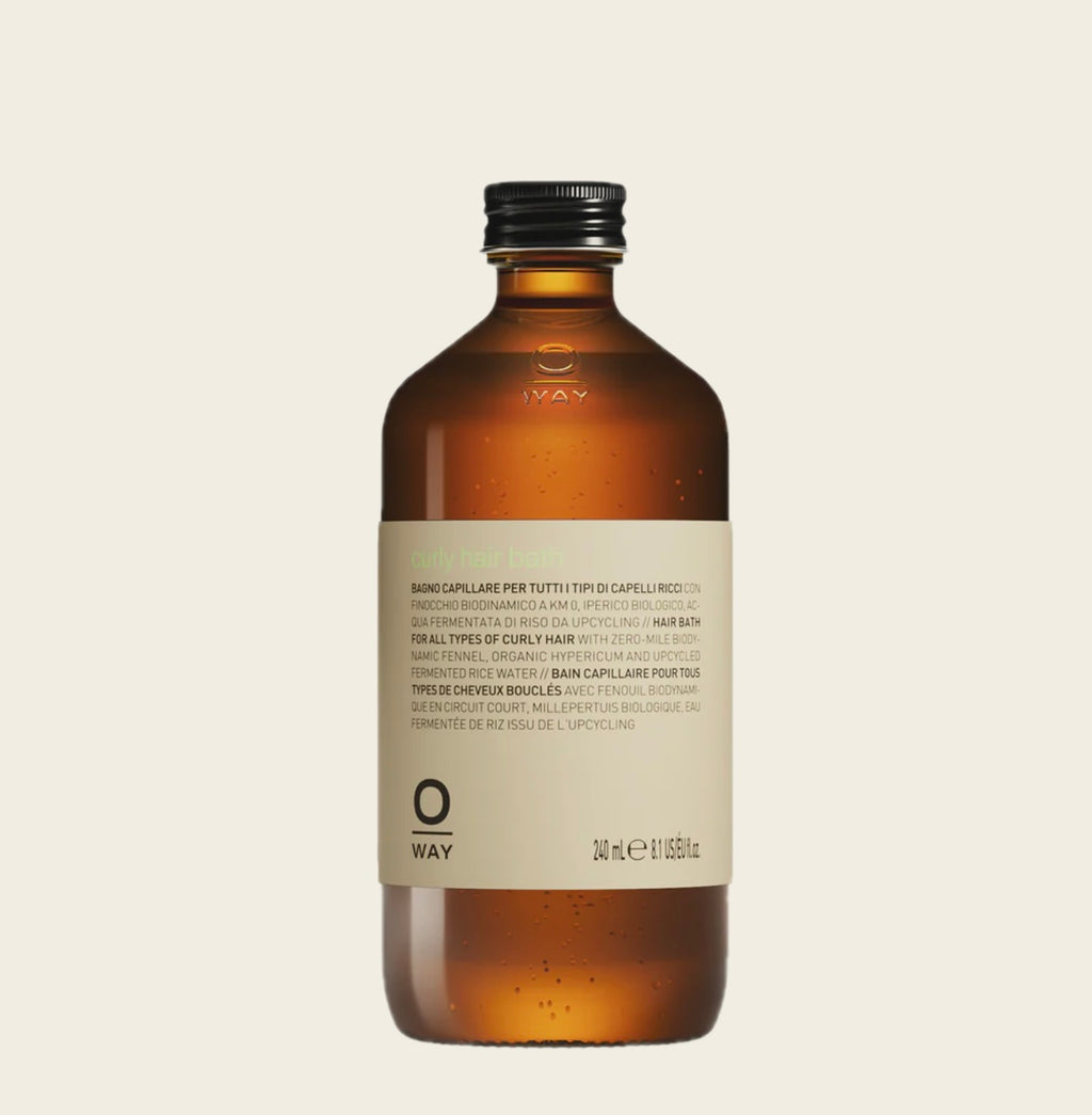 Oway Brown Curly Hairbath bottle with a label on a beige background